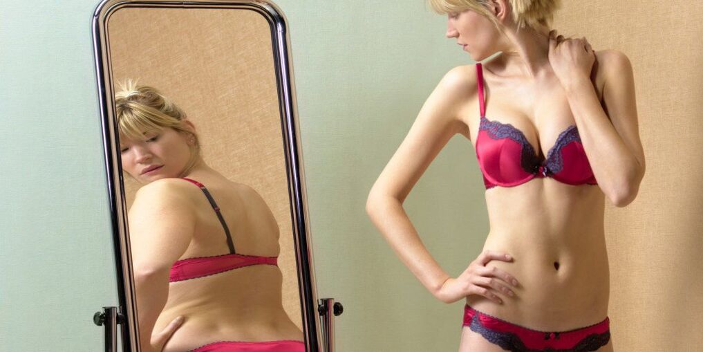 La fille regarde son reflet dans le miroir